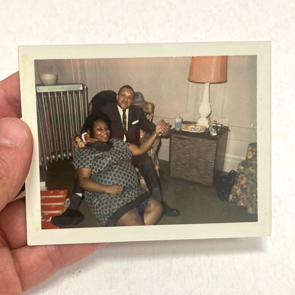 Photograph of African-American Man in Chair with Woman Seated on Floor between his legs